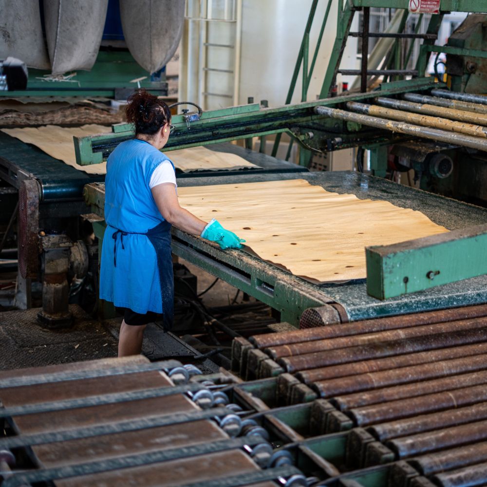 Operaia al lavoro su una macchina mentre sposta uno sfogliato